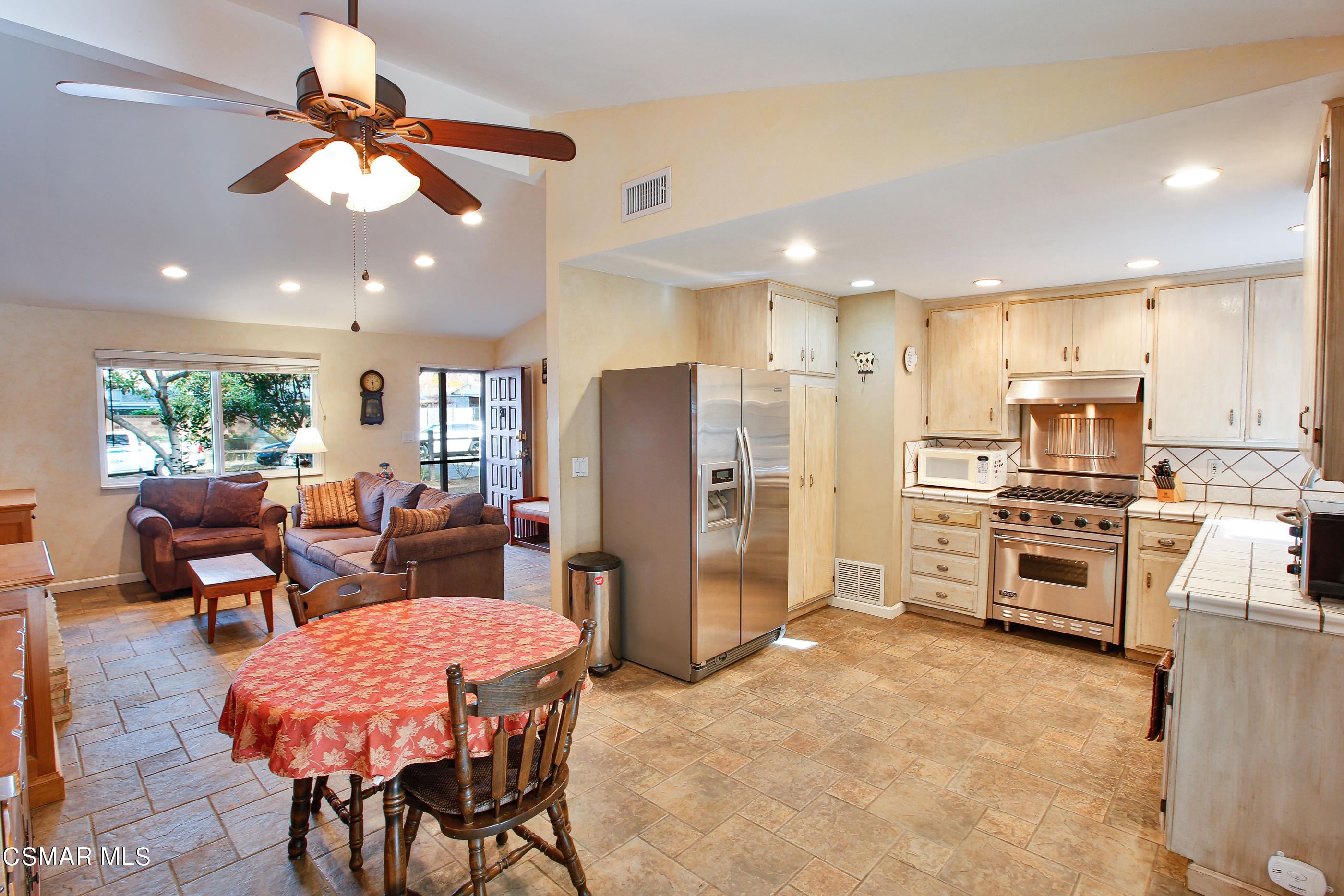 807 Talbert Avenue Simi Valley, CA 93065 - Photo 10 of 33 a open kitchen with stainless steel appliances kitchen island granite countertop a refrigerator a stove a sink dishwasher with a dining table and chairs with wooden floor