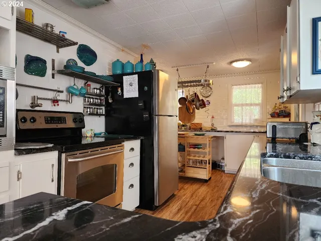 a kitchen with stainless steel appliances granite countertop a stove and a wooden floors