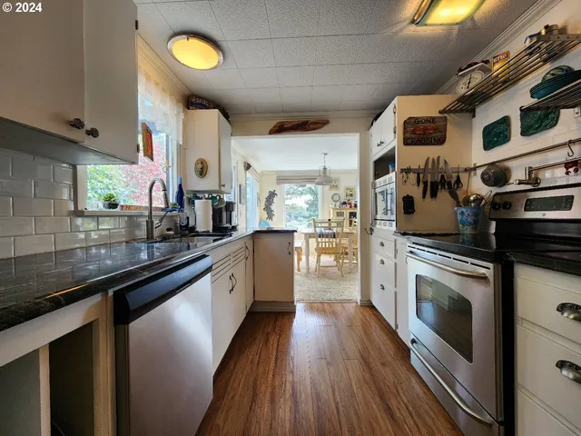 a kitchen with stainless steel appliances granite countertop a stove a sink and a microwave