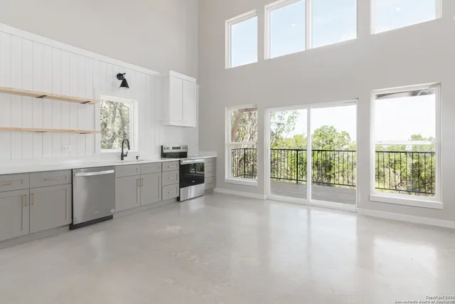 a kitchen with white cabinets and wooden floors