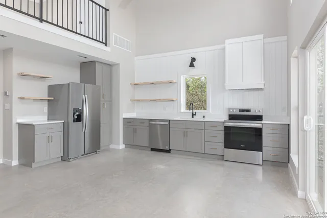 a kitchen with a refrigerator and a stove top oven