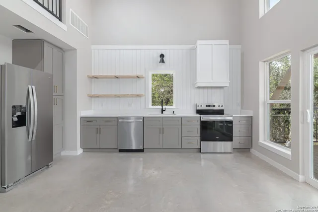 a kitchen with stainless steel appliances a stove a sink and a refrigerator