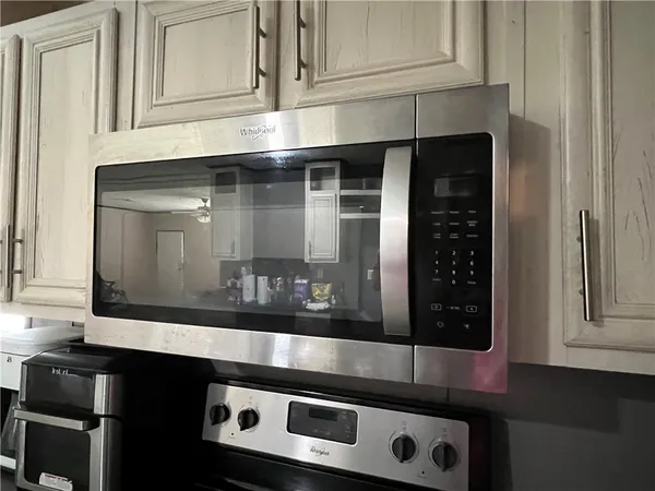 a kitchen with granite countertop white cabinets and black appliances