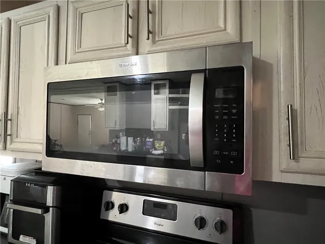 a kitchen with granite countertop white cabinets and black appliances