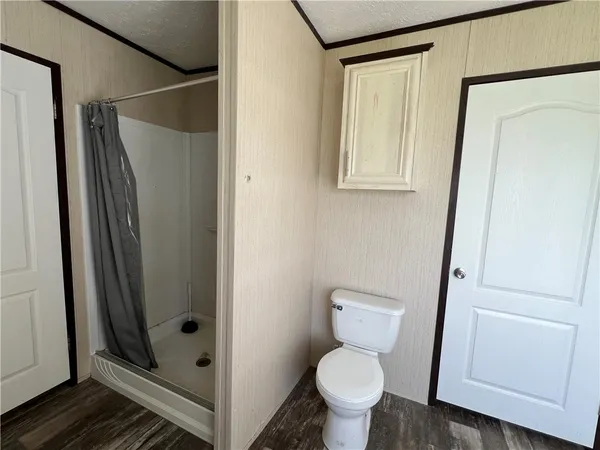 a bathroom with a toilet and a shower