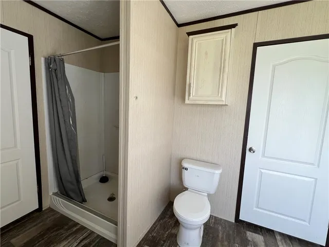 a bathroom with a toilet and a shower