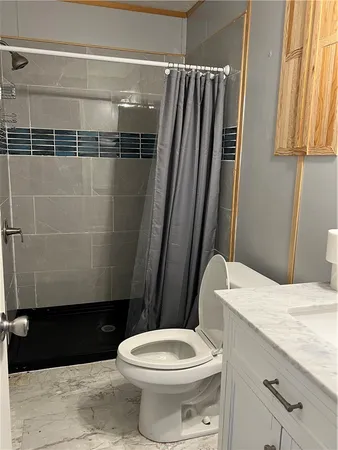 a bathroom with a granite countertop toilet sink and shower