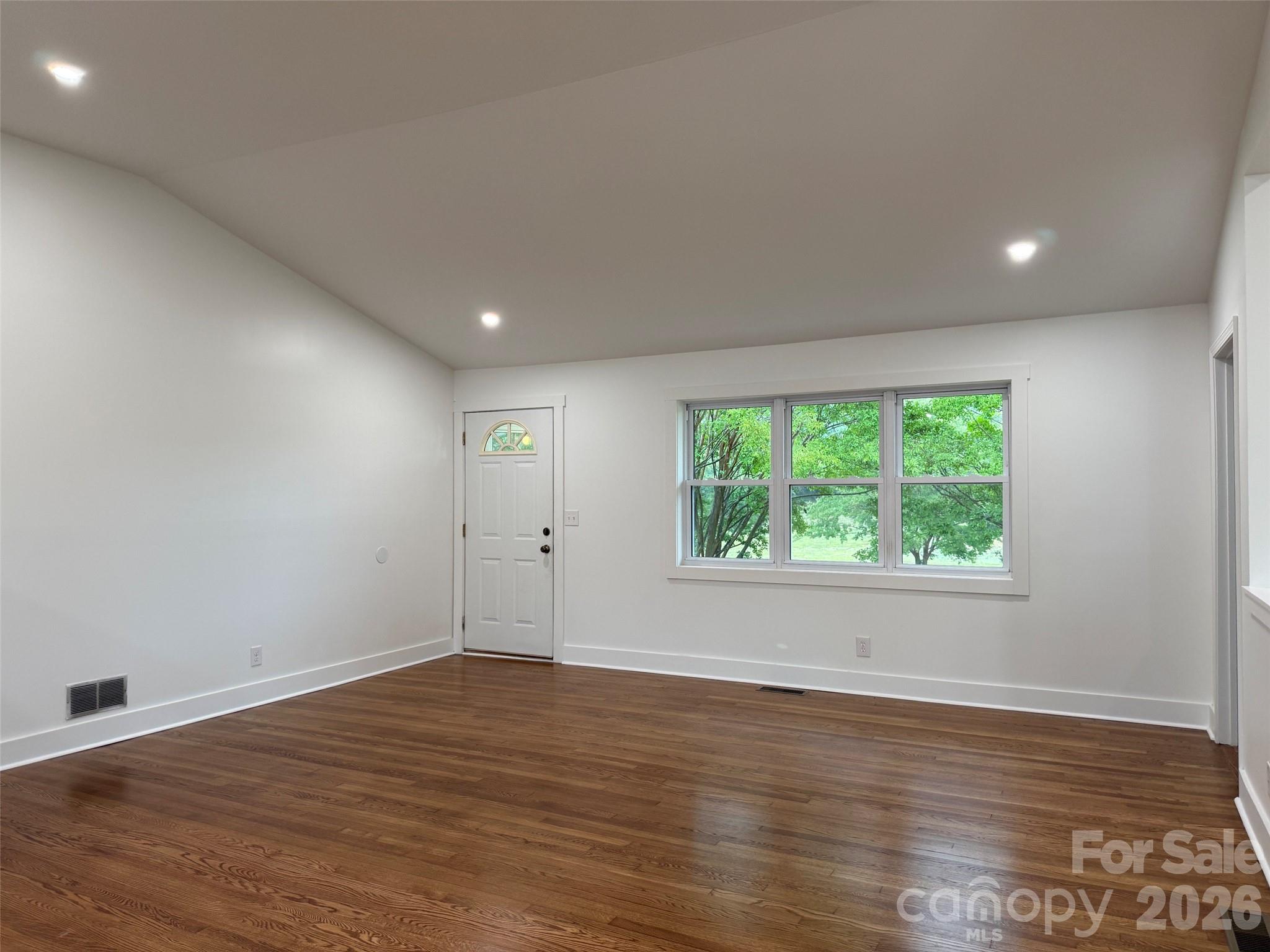 2677 Pax Hill Road Morganton, NC 28655 - Photo 5 of 15 an empty room with wooden floor and windows