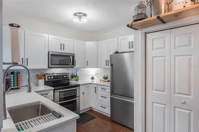 a kitchen with cabinets and stainless steel appliances