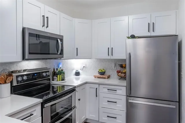 a kitchen with stainless steel appliances a stove a sink and a refrigerator
