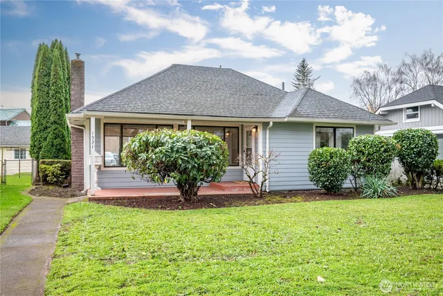 a front view of a house with a yard and potted plants