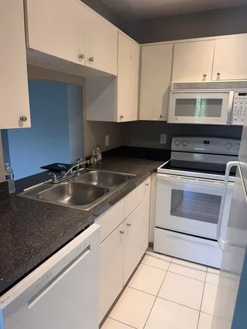 a kitchen with granite countertop a sink and a stove