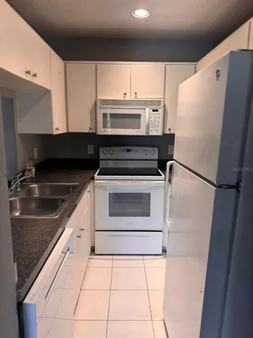 a kitchen with a refrigerator sink and cabinets