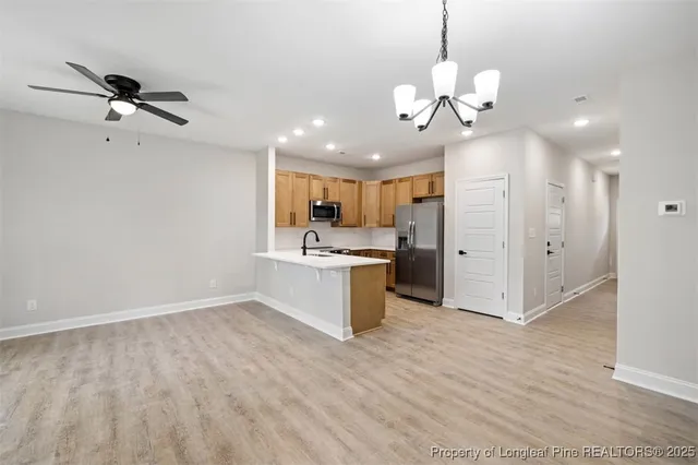 a view of a kitchen with a sink hardwood floor and a ceiling fan