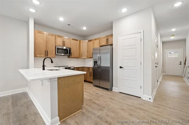 a kitchen with stainless steel appliances granite countertop a refrigerator and a sink