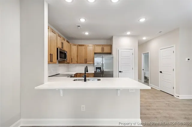 a large kitchen with kitchen island a sink stainless steel appliances and cabinets