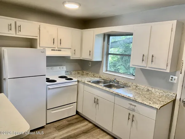 a kitchen with appliances a sink and cabinets