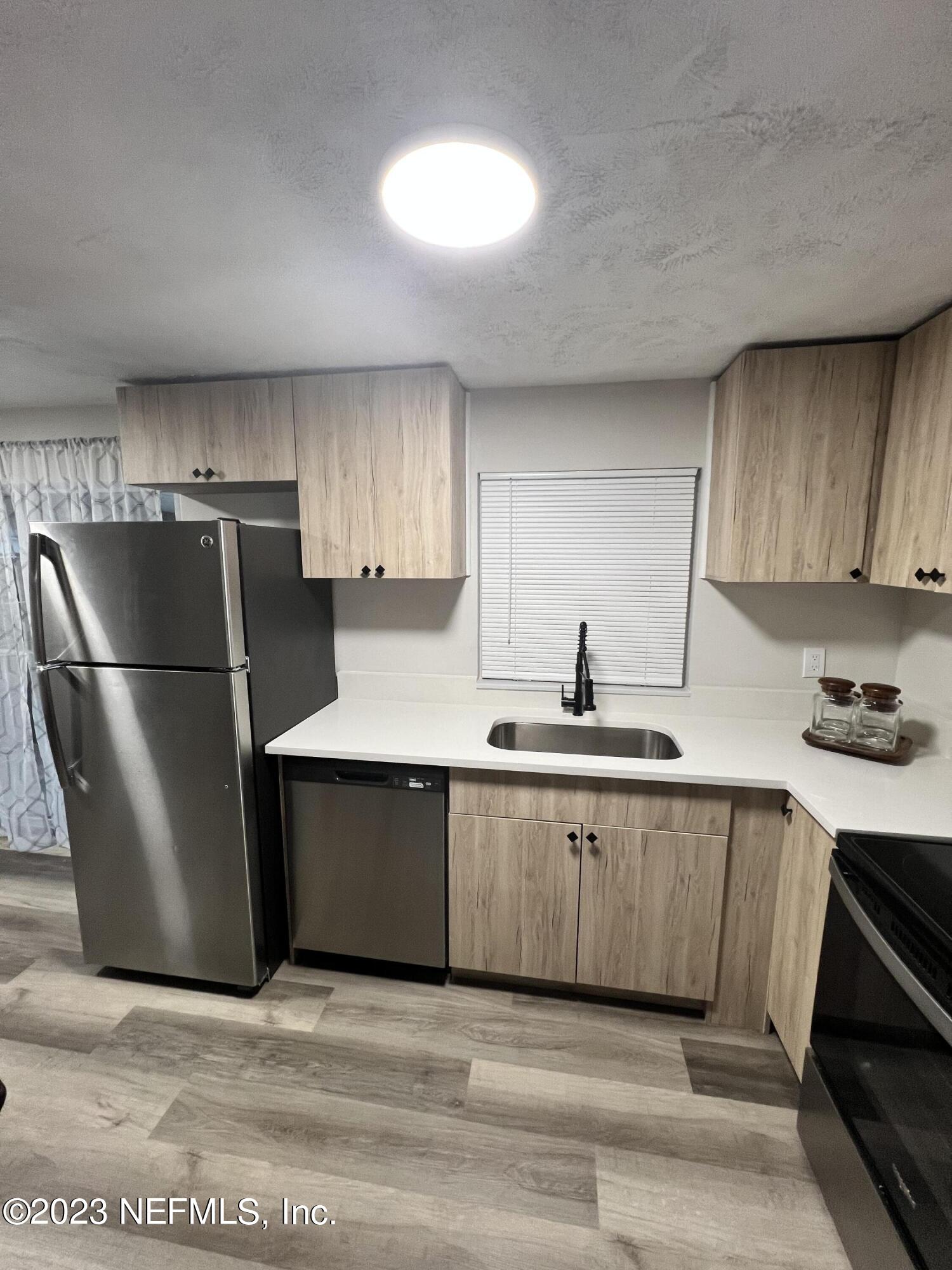 10892 Player Road Jacksonville, FL 32218 - Photo 10 of 37 a kitchen with stainless steel appliances granite countertop a refrigerator a sink a stove a microwave and island