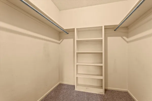 an empty room with a ceiling fan and window