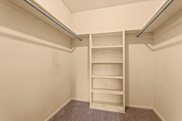 an empty room with a ceiling fan and window