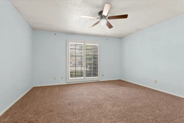 an empty room with chandelier fan