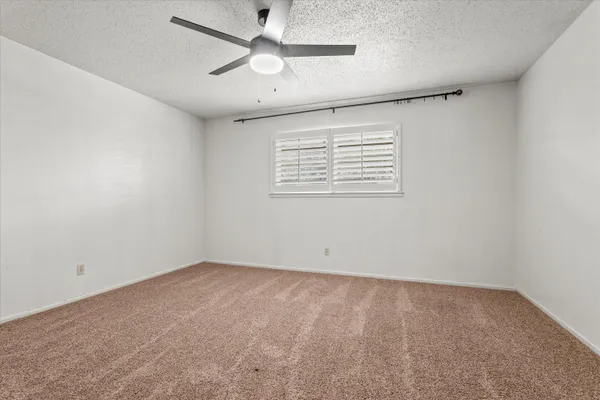 an empty room with chandelier fan