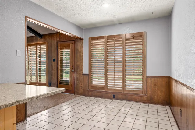 a large white kitchen with granite countertop a sink white cabinets and a wooden floor