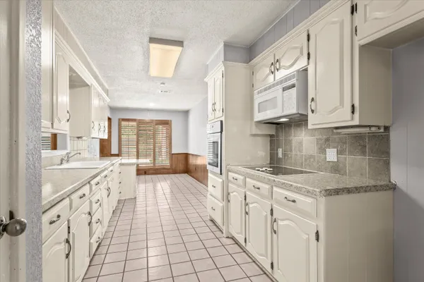 a kitchen with granite countertop a sink stove and cabinets