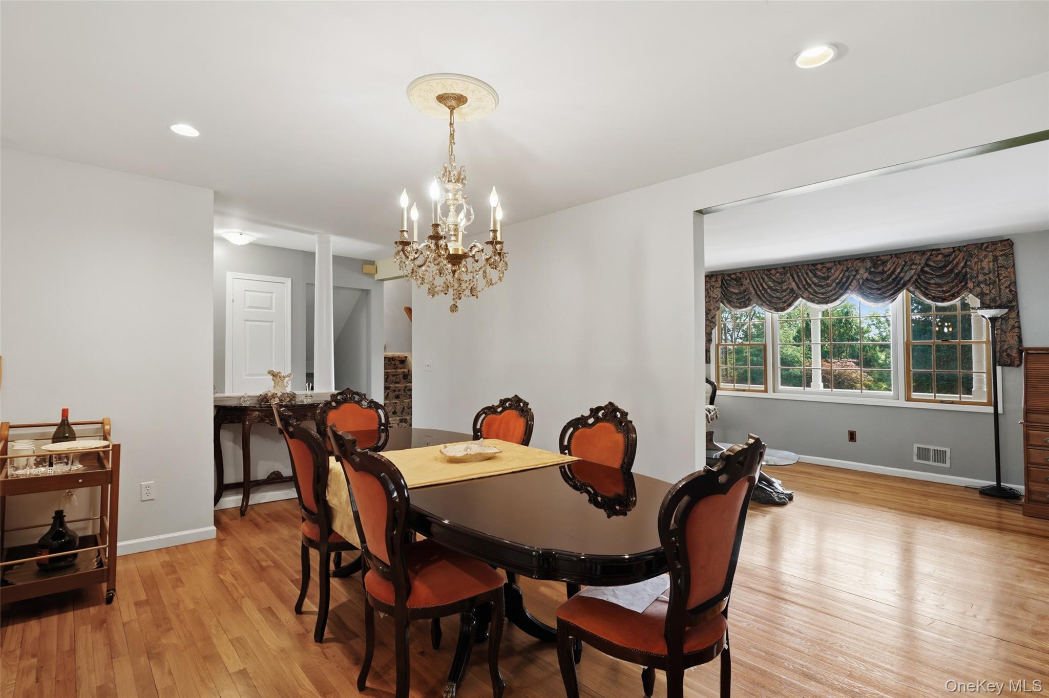 623 Cardinal Road Cortlandt Manor, NY 10567 - Photo 13 of 40 a view of a dining room with furniture a chandelier and wooden floor