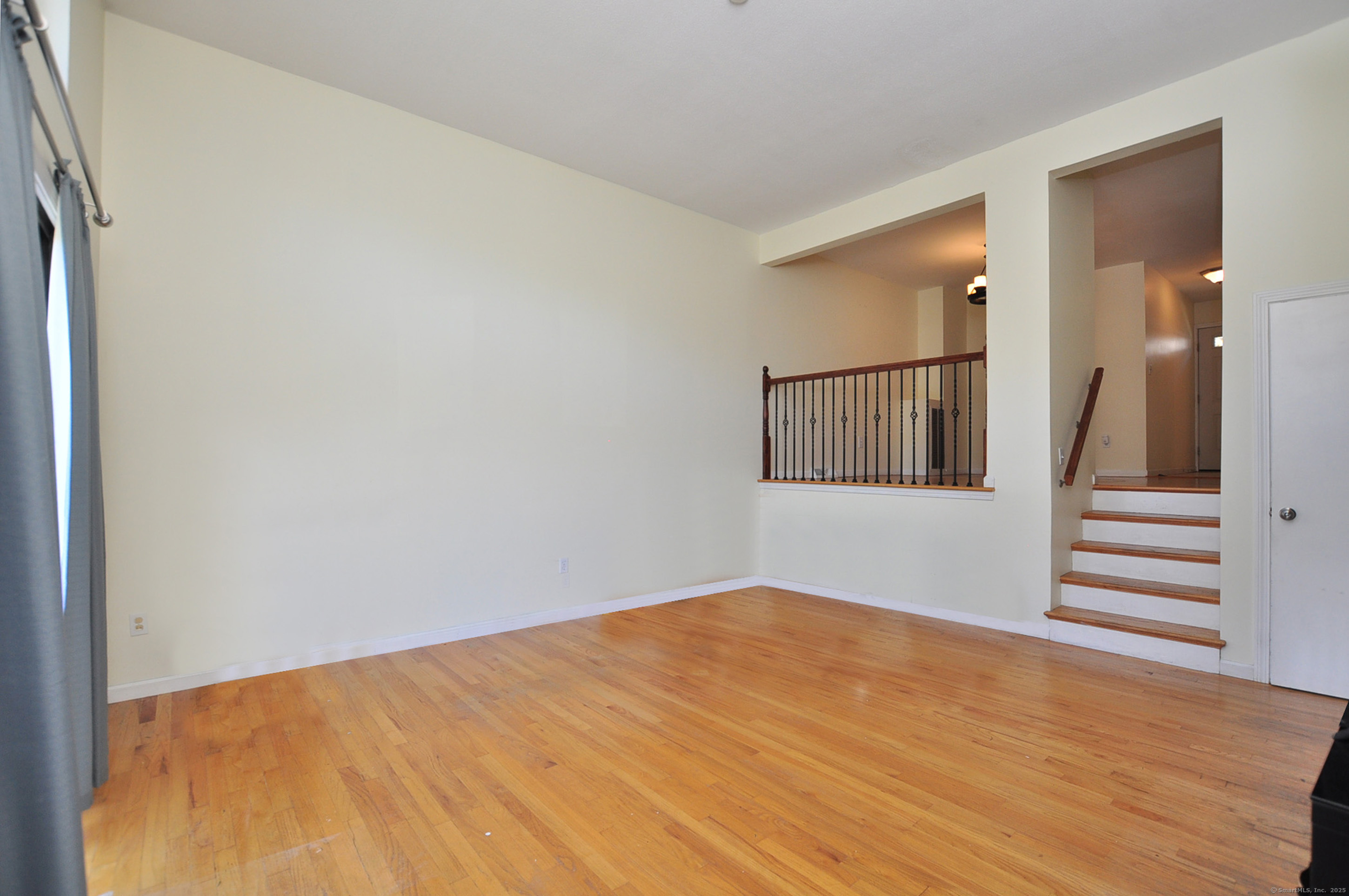 305 Timber Lane, Unit 305 Canton, CT 06019 - Photo 12 of 39 a view of an empty room with wooden floor and stairs