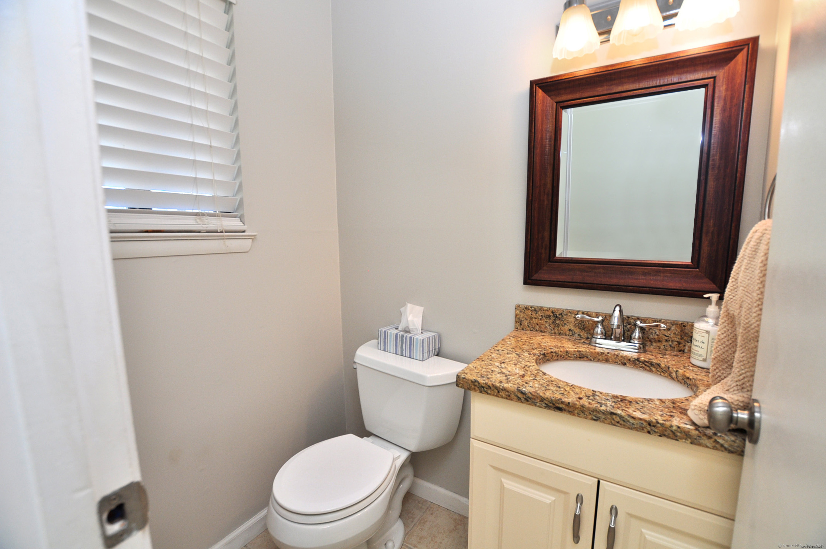 305 Timber Lane, Unit 305 Canton, CT 06019 - Photo 17 of 39 a bathroom with a granite countertop toilet sink and mirror