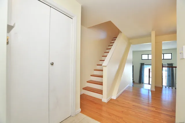 a view of a hallway with wooden floor and entryway