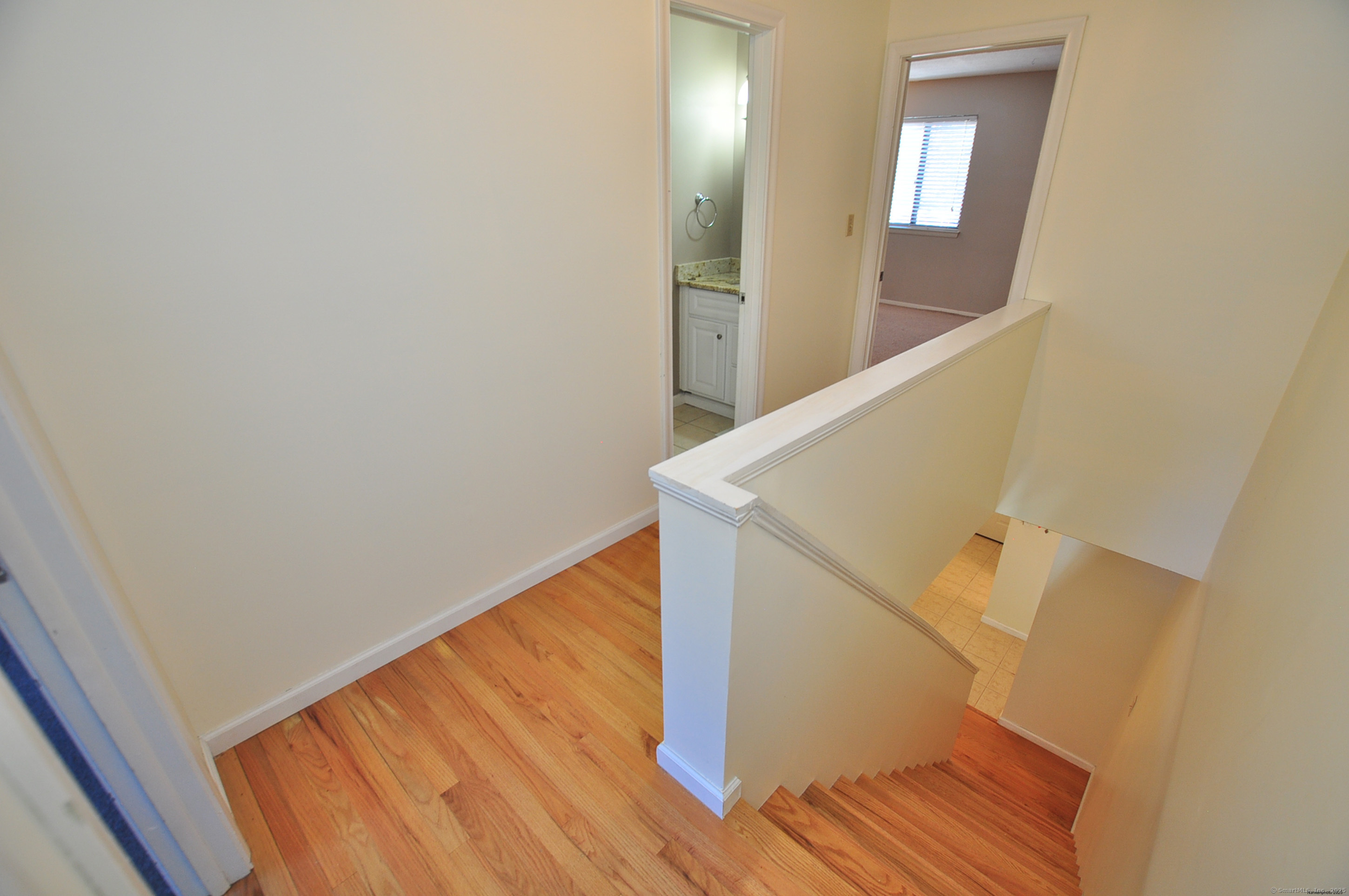 305 Timber Lane, Unit 305 Canton, CT 06019 - Photo 20 of 39 a view of a hallway with wooden floor and staircase