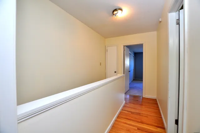 a view of hallway with wooden floor