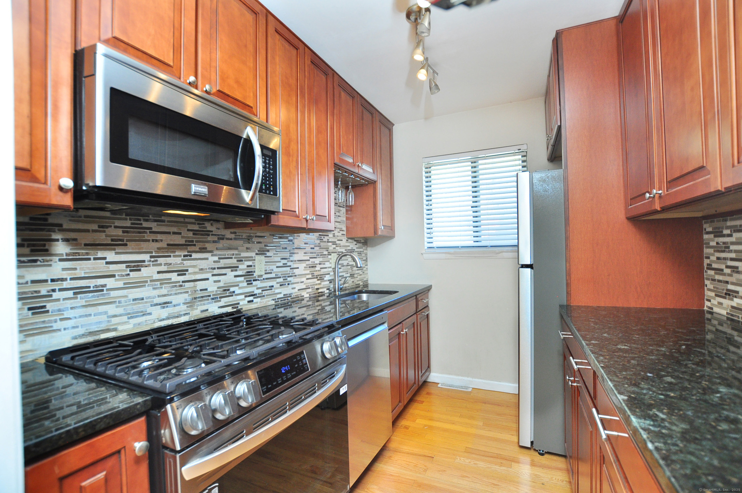 305 Timber Lane, Unit 305 Canton, CT 06019 - Photo 4 of 39 a kitchen with stainless steel appliances granite countertop a stove and a microwave