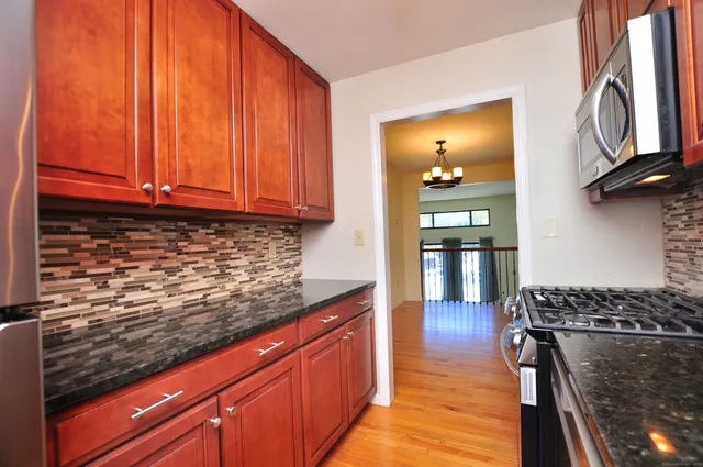 a kitchen with stainless steel appliances granite countertop a sink stove and cabinets