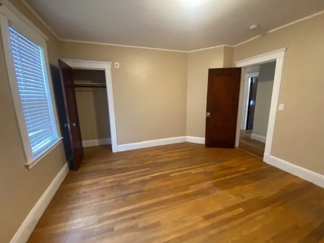 a view of an empty room with closet and a window