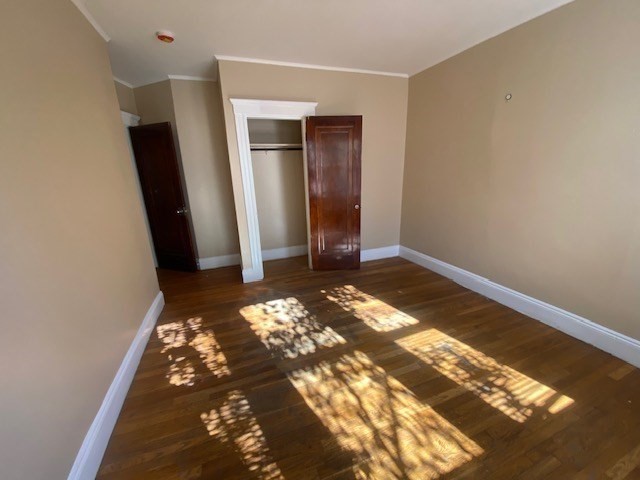 123 Glendower Road, Unit 1 Boston, MA 02131 - Photo 5 of 11 an empty room with wooden floor and closet