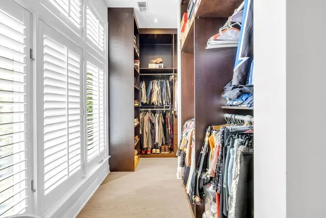 a living room with furniture a potted plant and a large window