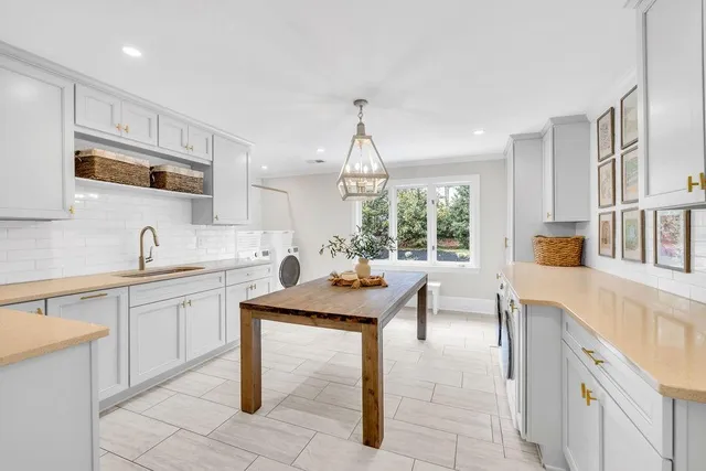 a large white kitchen with a sink and dishwasher with kitchen countertops