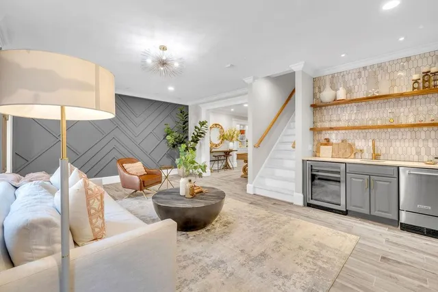 a view of swimming pool with seating space and trees in the background