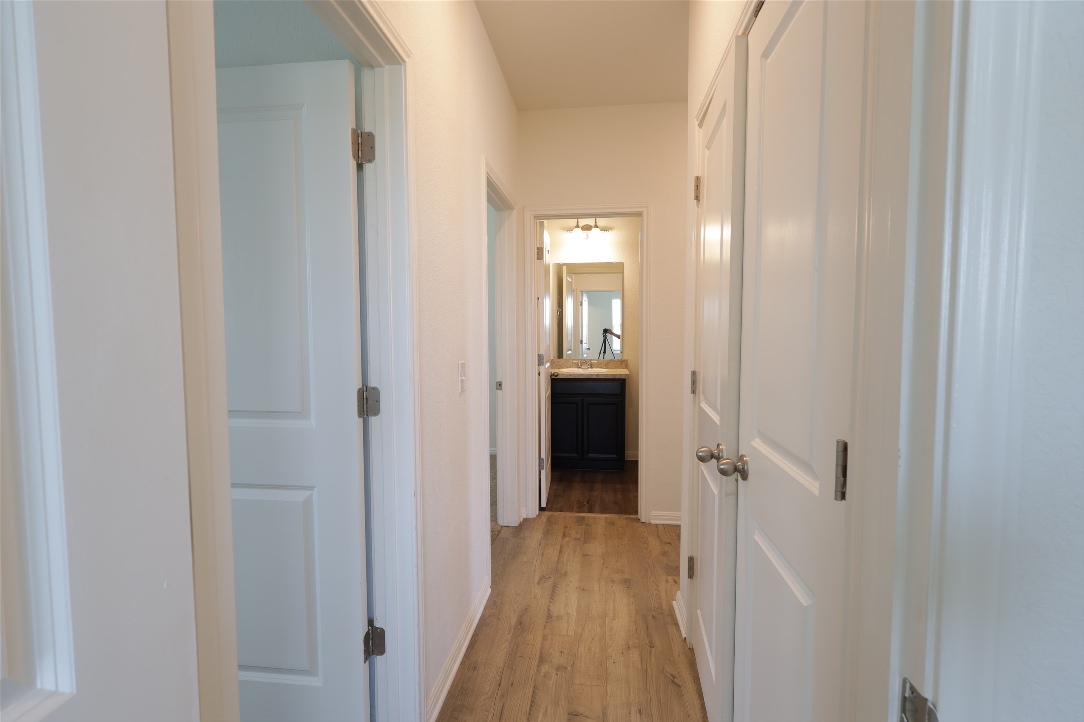 250 Seneca Loop Kyle, TX 78640 - Photo 14 of 22 A well-lit corridor guides residents past ample storage towards a functional bathroom vanity.