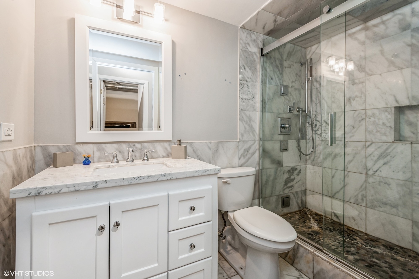 500 South Clinton Street, Unit 403 Chicago, IL 60607 - Photo 9 of 13 a bathroom with a granite countertop toilet a sink and a mirror