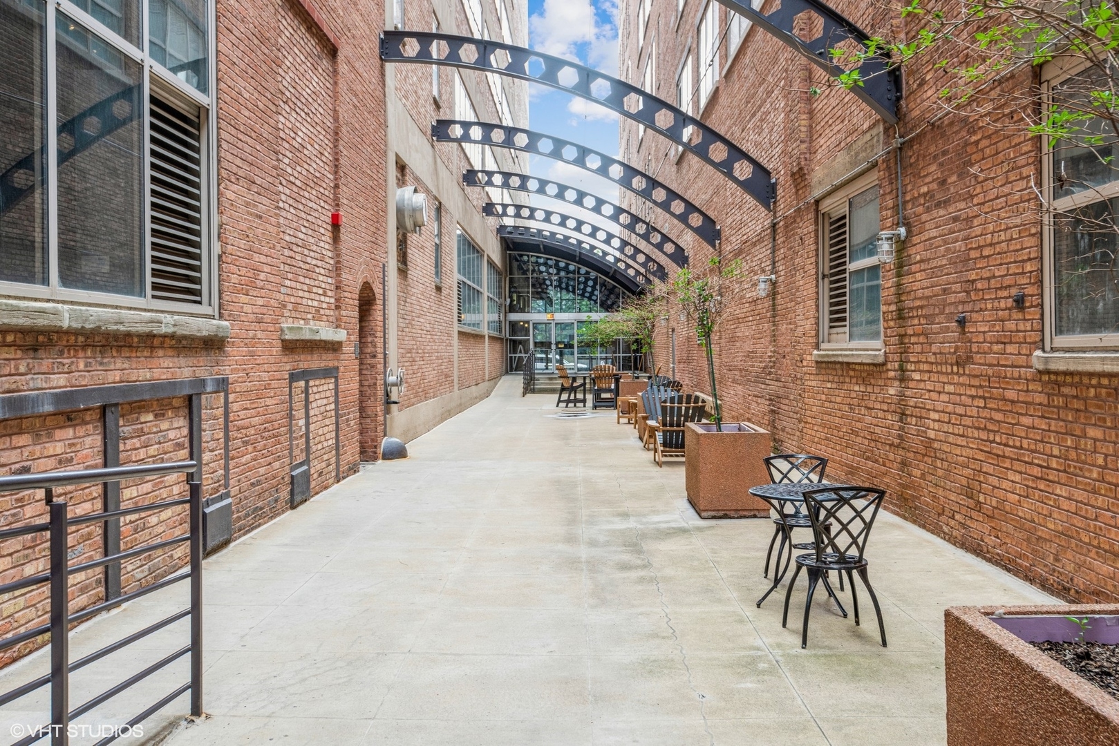500 South Clinton Street, Unit 403 Chicago, IL 60607 - Photo 10 of 13 a view of a patio with table and chairs with wooden floor and fence
