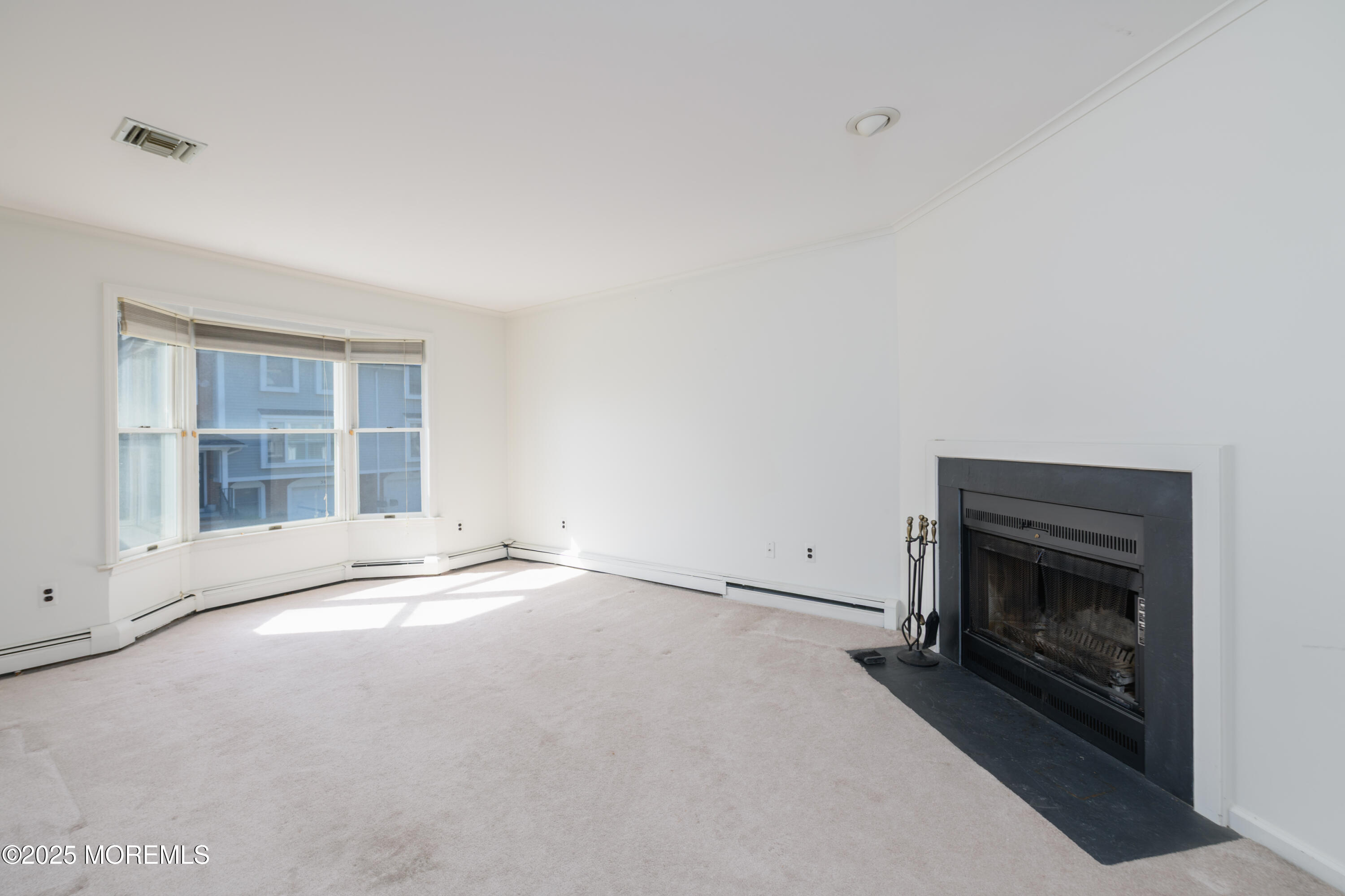 65 East River Road, Unit 14 Rumson, NJ 07760 - Photo 5 of 22 a view of an empty room with a fireplace and a window