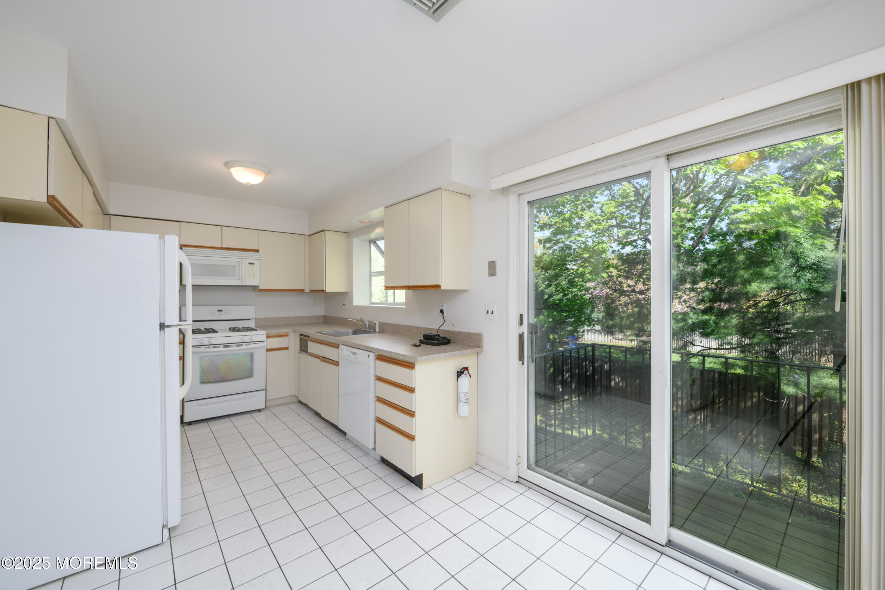 65 East River Road, Unit 14 Rumson, NJ 07760 - Photo 9 of 22 a kitchen with white cabinets and white appliances