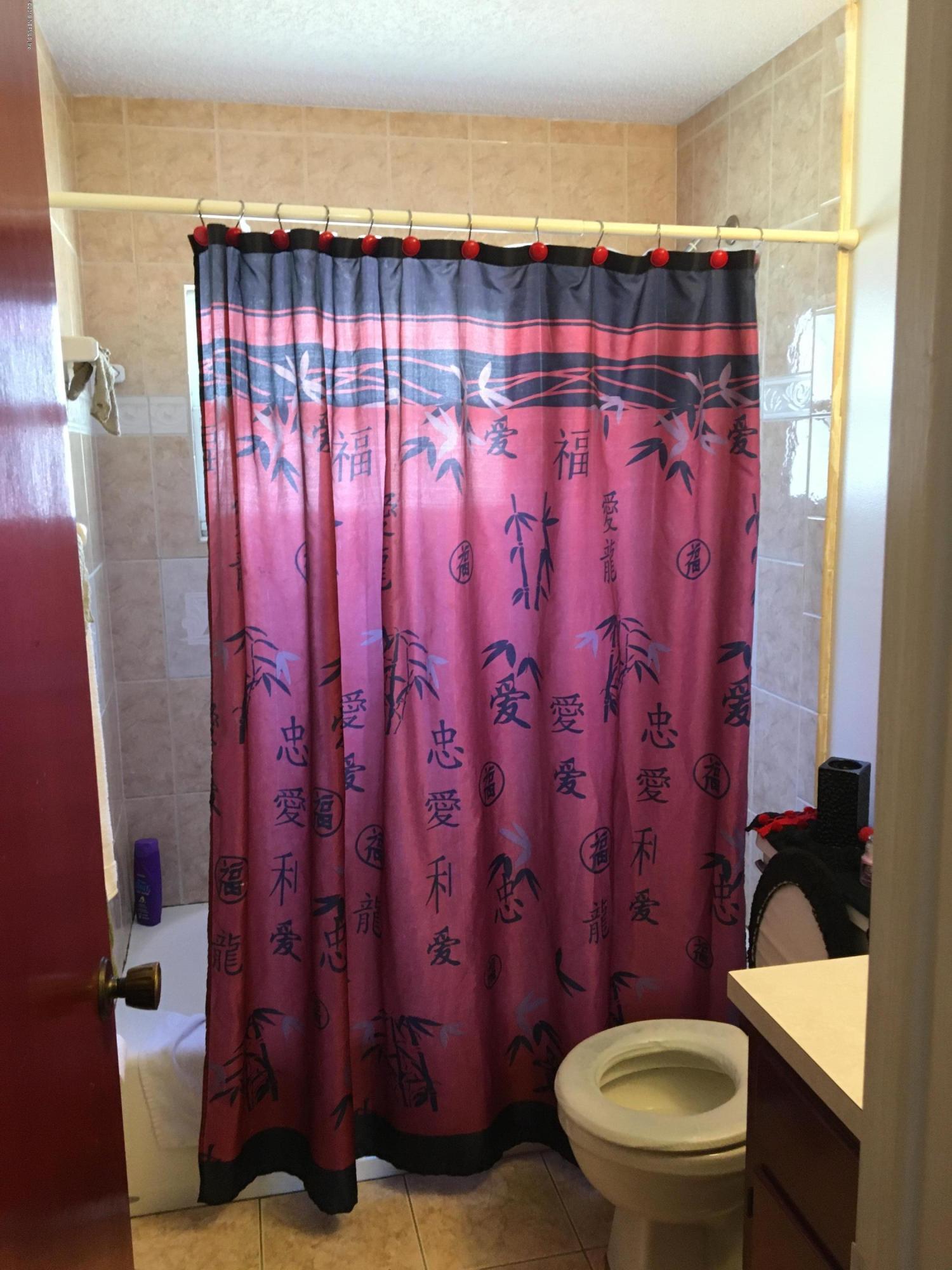 4870 Strato Road West Jacksonville, FL 32210 - Photo 8 of 14 a bathroom with a toilet and a shower curtain