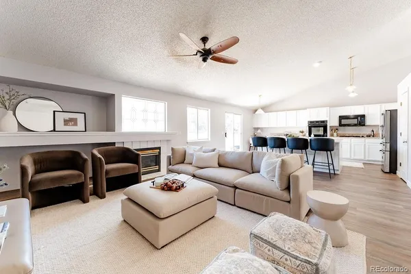 a living room with furniture kitchen view and a window