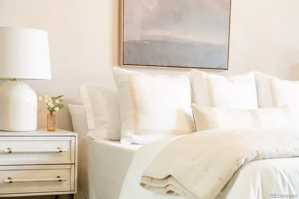 a bed sitting in a bedroom next to a lamp