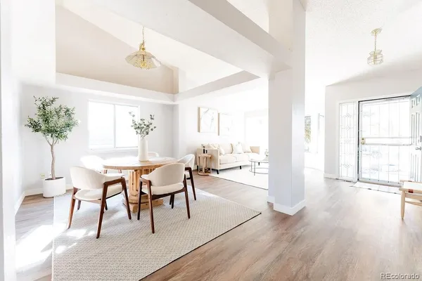 a dining room with furniture potted plants and wooden floor